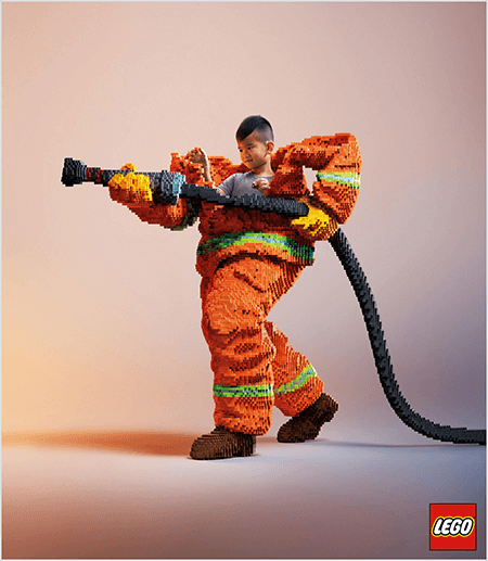 Tai nuotrauka iš LEGO skelbimo, kurioje matyti jaunas azijos berniukas iš LEGO pagamintos ugniagesio uniformos. Uniforma yra oranžinė su neonine žalia juostele aplink kailio ir kelnių rankogalius. Ugniagesys stovi atsilikęs viena koja ir laikosi ugnies žarną, taip pat pagamintą iš lego. Berniuko galva pasirodo iš uniformos viršaus, kuris yra daug didesnis nei jis, ir sustoja aplink pečius. Nuotrauka buvo padaryta paprastame neutraliame fone. „LEGO“ logotipas rodomas raudoname laukelyje apačioje dešinėje. Talia Wolf sako, kad LEGO yra puikus prekės ženklo, kuris reklamoje naudoja emocijas, pavyzdys.