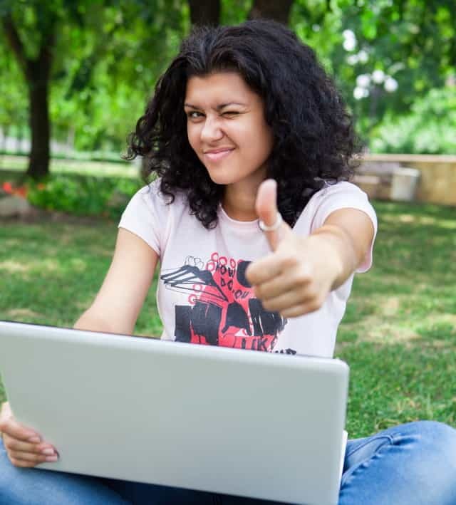 Mergina ant nešiojamojo kompiuterio parke